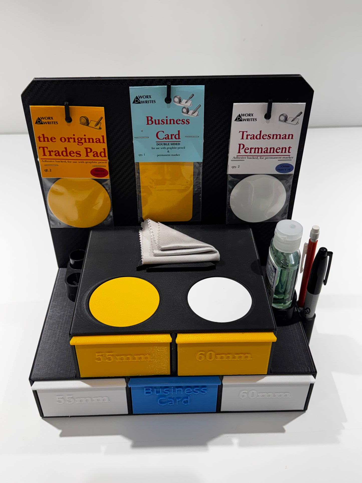 Front view of the Worx Writes retail soft start kit with black display stand featuring product cards and yellow, white, and blue pads, with pens and cloths, on a white counter.