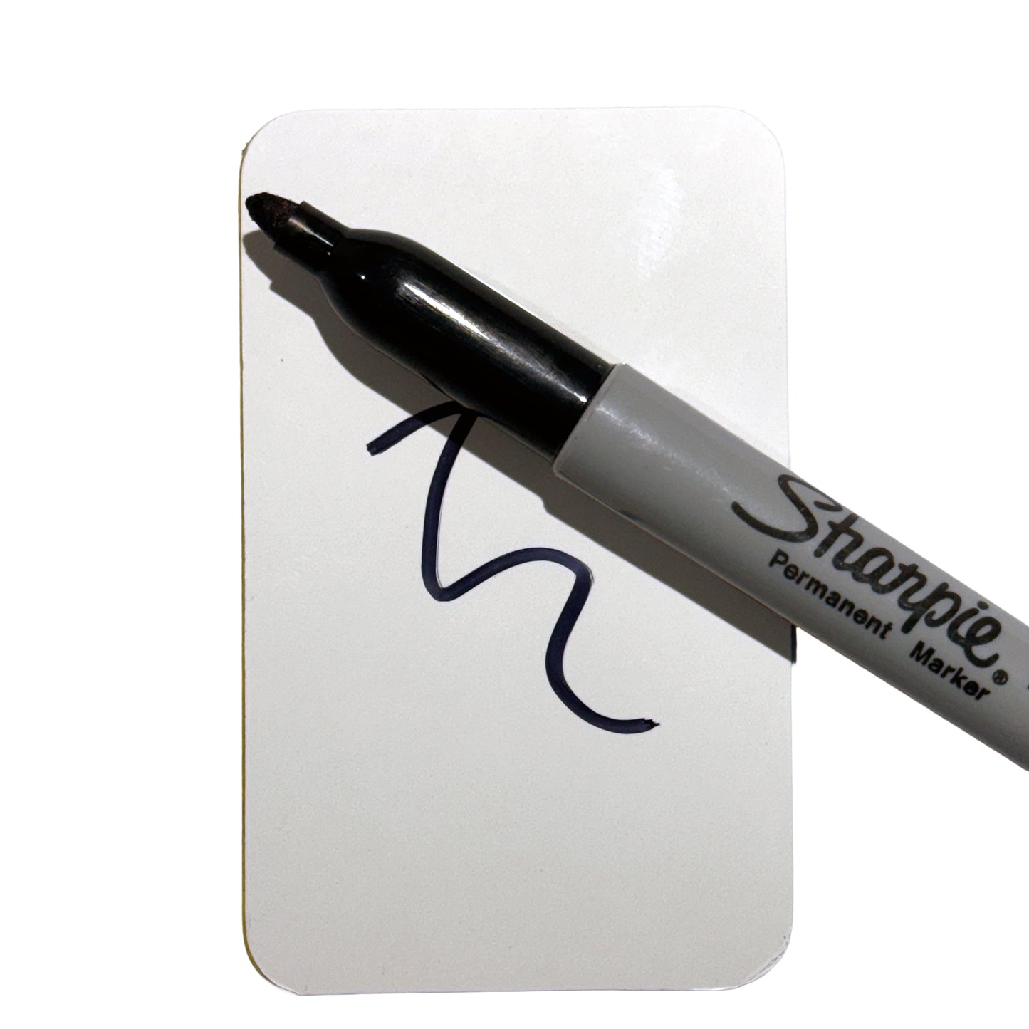 Black Sharpie permanent marker resting on a white Worx Writes Business Card pad with a wavy line drawn on the pad